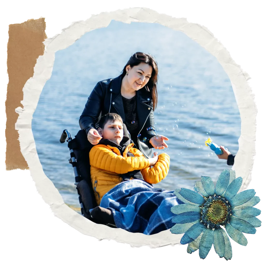 A disabled boy sitting in his wheelchair and his mother looking at bubbles