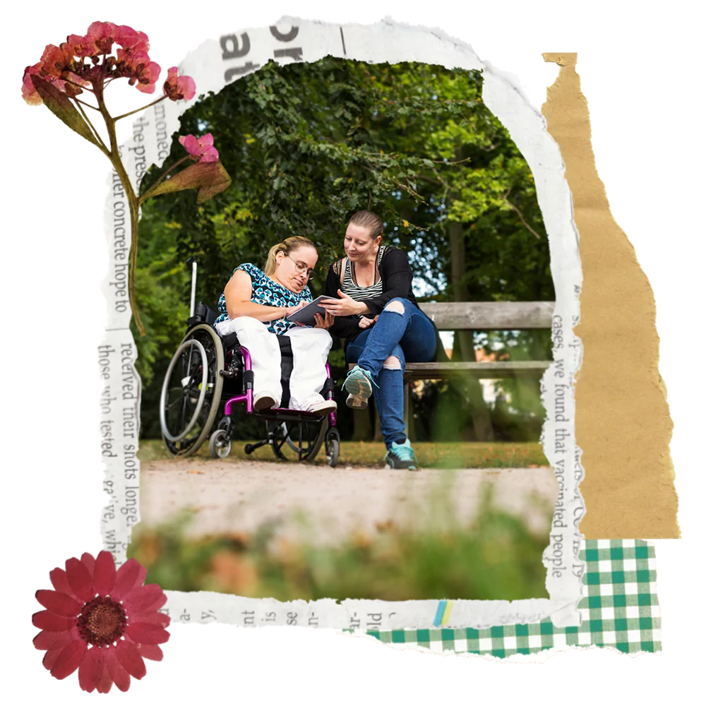 A disabled woman sitting in her wheelchair and her support worker looking at a tablet